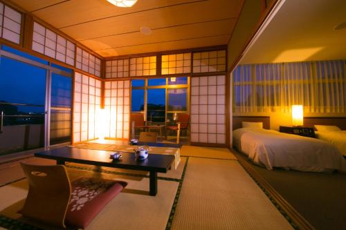 a bedroom with a bed and a desk in a room at Tashiro Annex in Yakushima