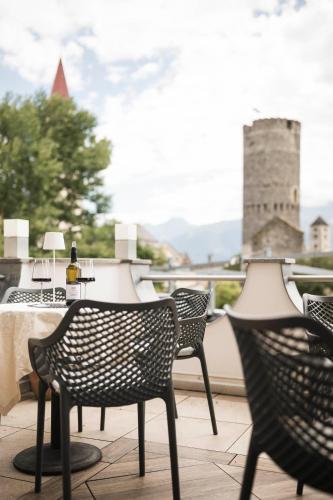 a group of chairs and a table on a balcony at Hotel Tyrol in Malles Venosta