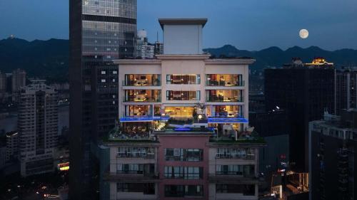 a tall building in a city at night at Tianya Wuxi river Hotel (Jiefangbei ) in Nan'an