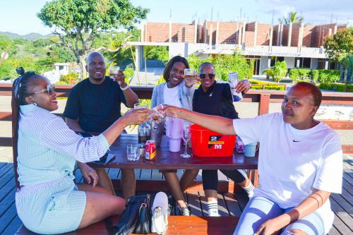 a group of people sitting around a picnic table at Ponta View Hotel in Ponta do Ouro