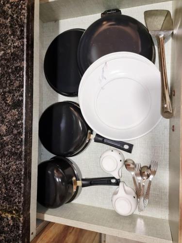 a shelf with pots and pans and utensils at TheDreamystay dreamy Balcony View in Greater Noida