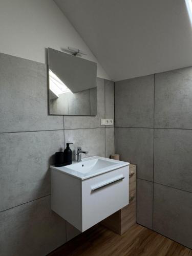 a bathroom with a white sink and a mirror at Casa del Mondo 3 in Sankt Aldegund