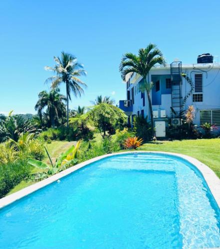 a swimming pool in front of a house at Swim & Paint Art Retreat in Las Piedras
