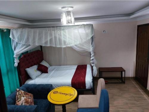 a bedroom with a bed with a canopy and a couch at Toque Grill B&B in Nairobi