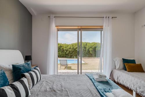 una camera da letto con un letto e una porta scorrevole in vetro di A Casa da Vagem a Pernigem