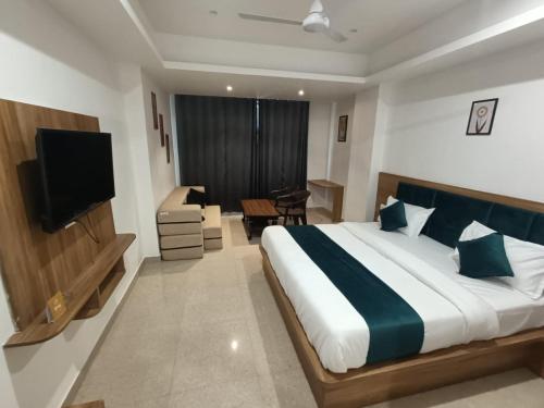a bedroom with a bed and a television and a desk at Hotel Raas Inn, New Hotel in Udaipur