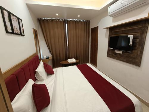 a hotel room with a bed and a television at Hotel Raas Inn, New Hotel in Udaipur