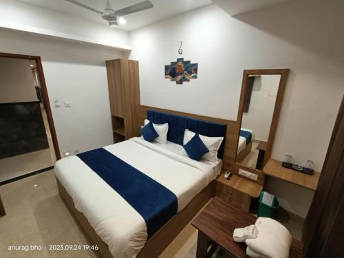 a bedroom with a bed with blue and white sheets at Hotel Raas Inn, New Hotel in Udaipur