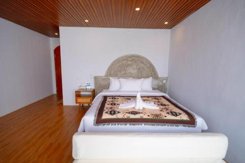 a bedroom with a bed with a large headboard at Lake Batur Villa in Kubupenlokan