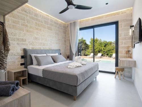 a bedroom with a bed and a brick wall at PanStel - Villa Solene with private pool in Ayiá