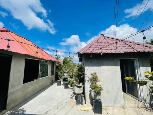 a house with a red roof and a patio at Yu BAMBOOS AIRPORT TRANSIT HOTEL in Seeduwa