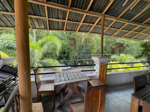 a patio with a table and chairs and a grill at Yu BAMBOOS AIRPORT TRANSIT HOTEL in Seeduwa