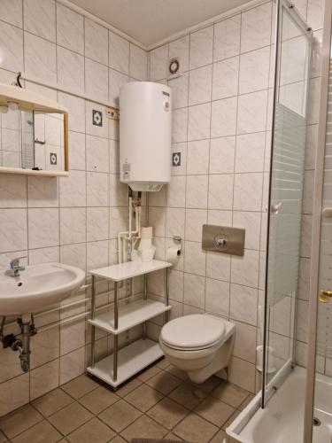 a bathroom with a toilet and a sink and a shower at Pension Moers am Geleucht in Moers