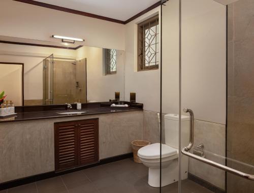 a bathroom with a toilet and a sink and a shower at Tamarind Tree Garden Resort - Katunayake in Negombo
