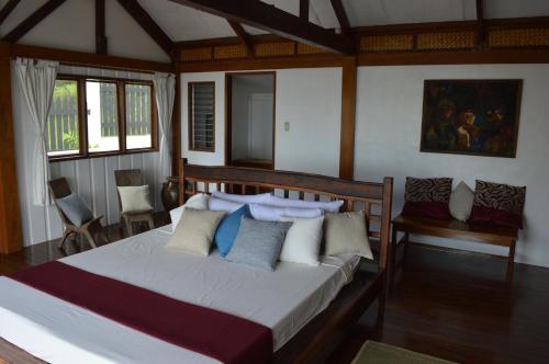 a bedroom with a large bed with blue and white pillows at The Amazing Villa in Anepahan