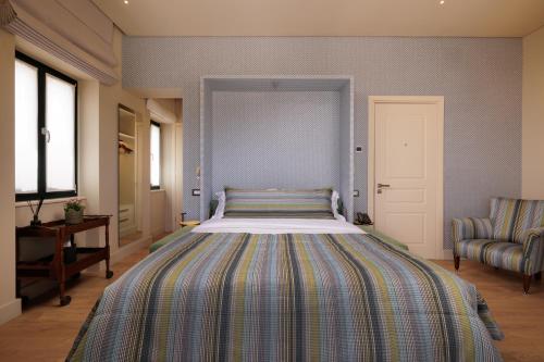 a bedroom with a large bed with a striped bedspread at Albergo Botti in Corfu Town
