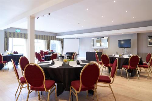 a conference room with tables and chairs and a tv at Best Western Plus The Connaught Hotel and Spa in Bournemouth