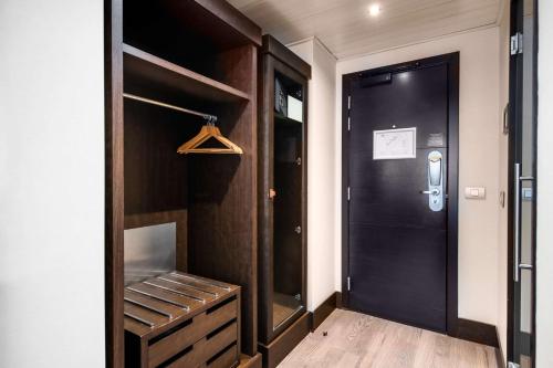 a hallway with a black door and a closet at NH Brussels Stéphanie in Brussels