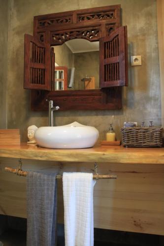 a bathroom with a sink and a mirror and towels at Casa do Páteo in Aldeia do Meco