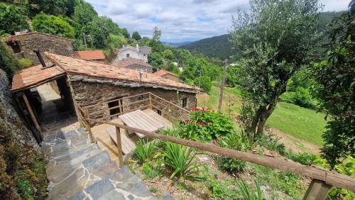 an old stone building with a house on a hill at Casa do Forno in Miranda do Corvo