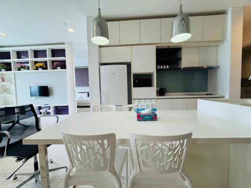 a kitchen with a white table and chairs at THE PLATINUM KLCC by COZY STAY in Kuala Lumpur