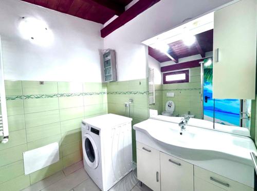 a bathroom with a washing machine and a sink at Villa Julien Quartu Sant'Elena Sardegna in Santa Luria