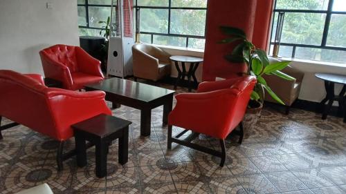 ein Wartezimmer mit roten Stühlen und einem Tisch in der Unterkunft Buki Hotel in Nakuru