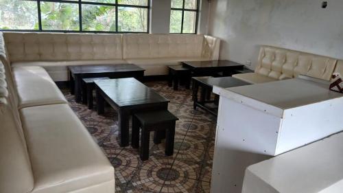 ein Restaurant mit Sofas und Tischen und einer Couch in der Unterkunft Buki Hotel in Nakuru