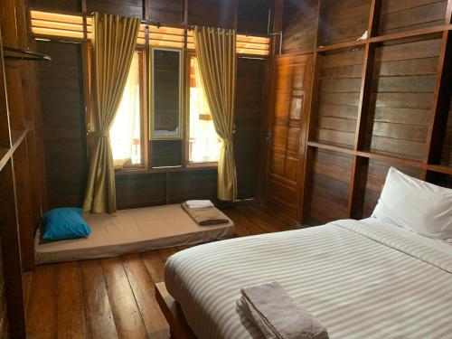 a bedroom with a bed and a window at Pandan View Mandeh in Pasarsungai-nyala