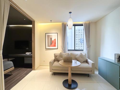 a living room with a couch and a table with a laptop at Express by M Village Nguyễn Bỉnh Khiêm in Ho Chi Minh City