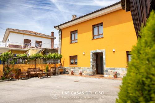 a yellow house with a patio in front of it at Villa Marina - Las Casas del Oso in Granda