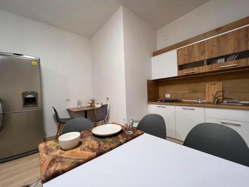 a kitchen with a table and chairs and a refrigerator at Kino Apartment in Tirana