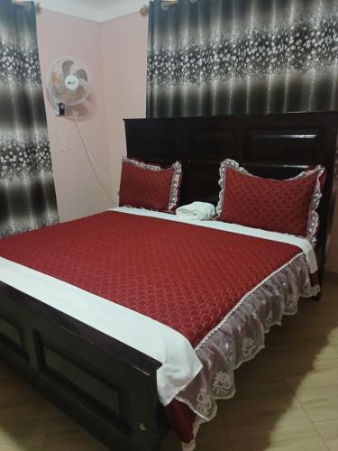 a bed with red pillows in a room at Panda hotel in Entebbe
