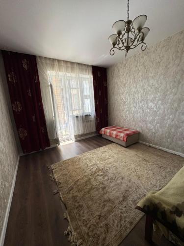 an empty living room with a couch and a chandelier at Аэропорт Мечеть ЭКСПО in Astana