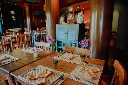 a wooden table with napkins on it in a restaurant at Rawi Warin Resort And Spa - SHA Extra Plus in Ko Lanta