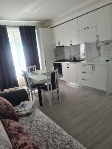 a living room with a table and a kitchen at Luxury Property with 2bdm Radauti in Rădăuţi