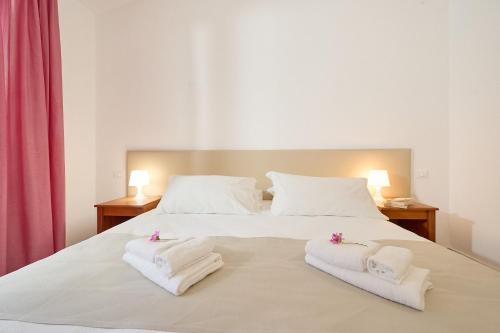 a bedroom with a bed with towels on it at Villaggio Orizzonte in Riotorto