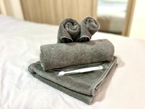 a pile of towels and a pen on a bed at Terrace Tokyo Skytree in Tokyo