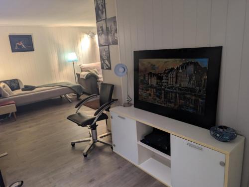 a living room with a flat screen tv on a entertainment center at Close to Karmøy and Haugesund airport in Karmøy