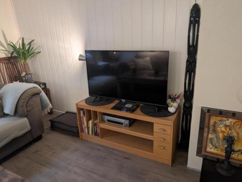 a living room with a flat screen tv on a stand at Close to Karmøy and Haugesund airport in Karmøy