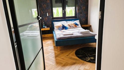 a room with a blue chair and a window at Apartament Boosko Ciao! in Busko-Zdrój