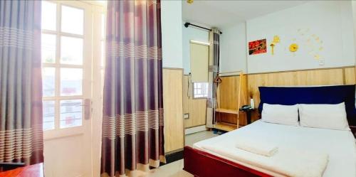 a bedroom with a bed and a large window at Khách sạn Ngọc Thủy in Phan Rang
