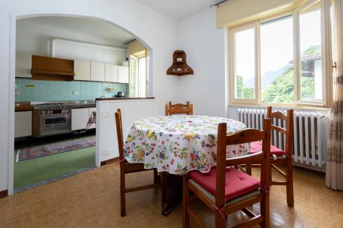 a kitchen with a table and some chairs and a table and a table at housecurti1 in Sorico