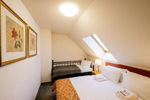 a small room with two beds in a attic at Apparthotel Bad Schandau by STEIGER Hotels in Bad Schandau
