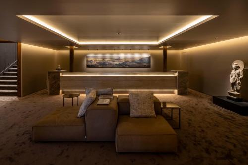 a living room with a couch and a table at Momoyama Onsen Tsukimikan in Kyoto