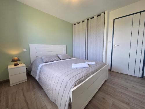 une chambre avec un lit avec deux serviettes dessus dans l'établissement Maison au Coeur du Perche Arcisses Margon, à Margon