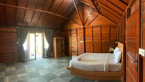 a bedroom with a bed in a wooden room at Pandan View Mandeh in Pasarsungai-nyala