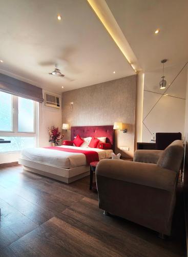 a large bedroom with a large bed and a couch at Hotel Gurveer Royal in Lucknow