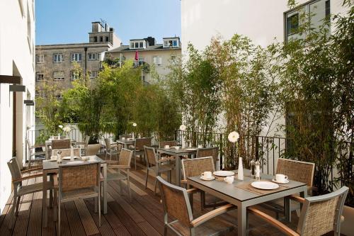 a patio with tables and chairs on a balcony at NH Frankfurt Messe in Frankfurt/Main