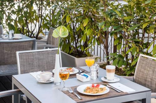 a table with food and drinks on a patio at NH Frankfurt Messe in Frankfurt/Main